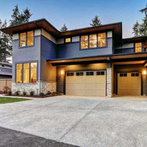 DOOR Luxurious new construction home in Bellevue, WA. Modern style home boasts two car garage framed by blue siding and natural stone wall trim. Northwest, USA